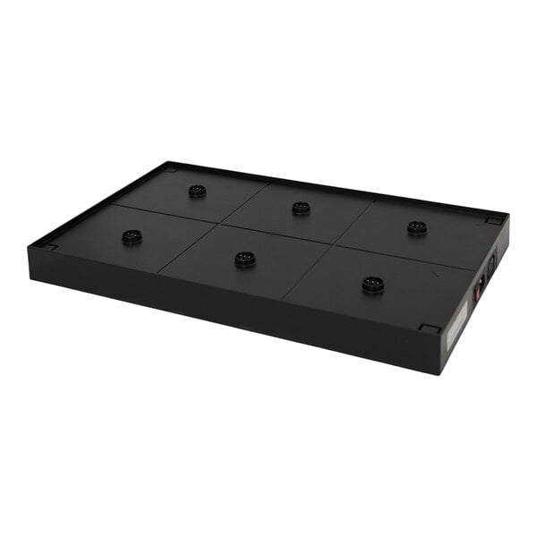 A rectangular black platform with six evenly spaced circular contact points on its surface and a control panel on one side.