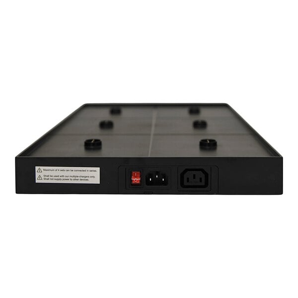 A rectangular black charging platform with multiple contact points and three power connectors on one side.