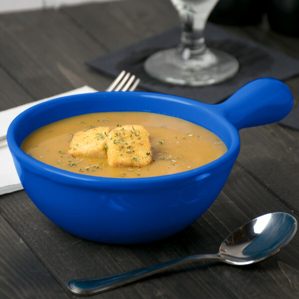 A Tablecraft cobalt blue cast aluminum soup bowl with soup and croutons.