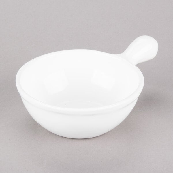 A Tablecraft white cast aluminum soup bowl with a handle.