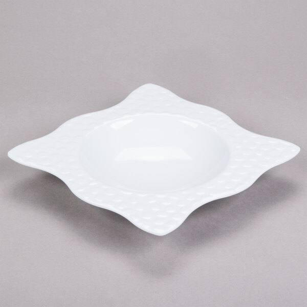 A white square melamine bowl with a pattern on it.