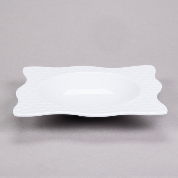 A white square melamine bowl with a wavy design.