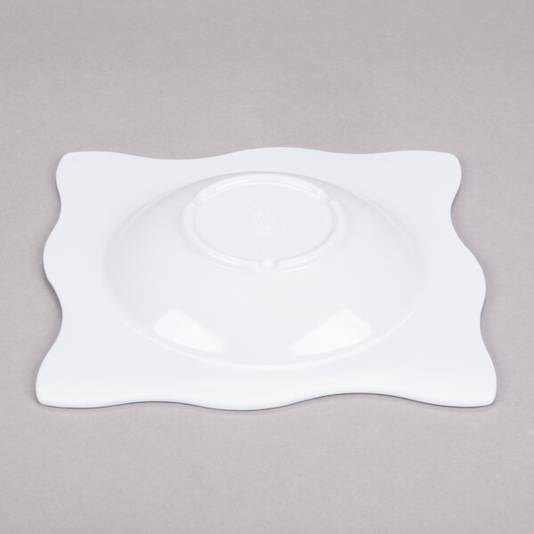 A white square melamine bowl on a gray surface.