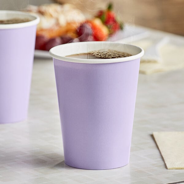 Two Luscious Lavender purple paper cups filled with coffee on a table.
