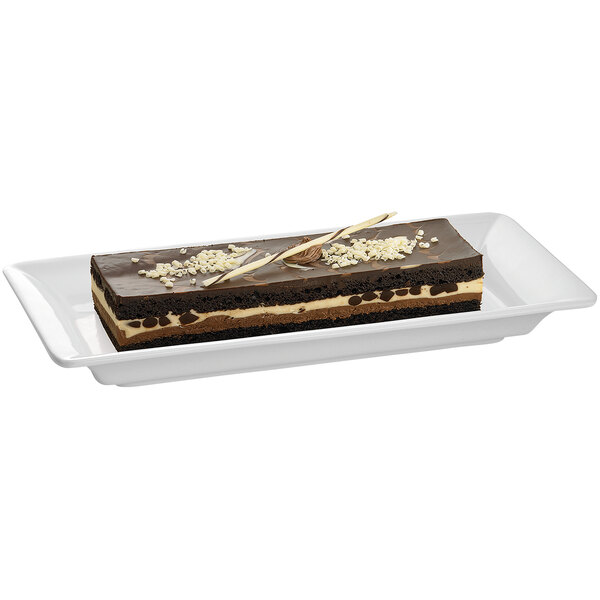 A rectangular chocolate cake on a white Tablecraft platter.