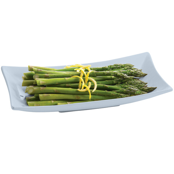 A Tablecraft gray cast aluminum flared rectangular platter with asparagus and lemon zest.