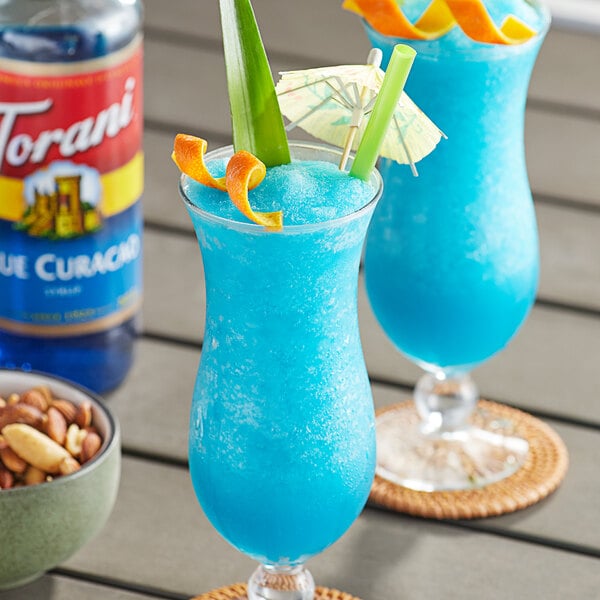 A blue curcacao drink with an orange peel garnish