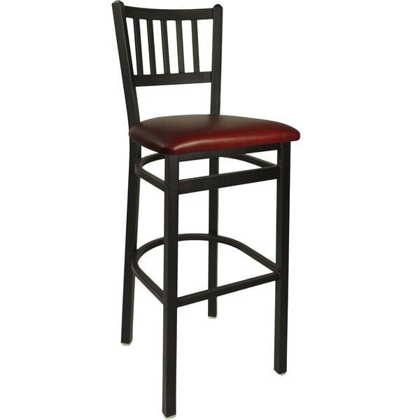 A BFM Seating black metal bar height chair with a burgundy vinyl seat.