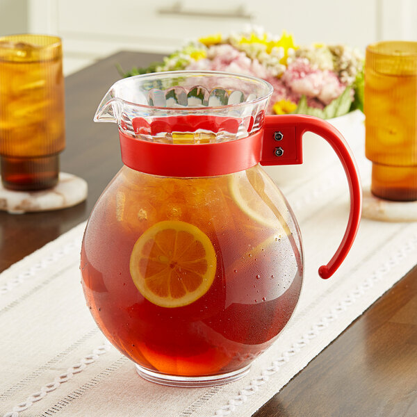 A GET Tahiti clear plastic pitcher with orange liquid and lemon slices.