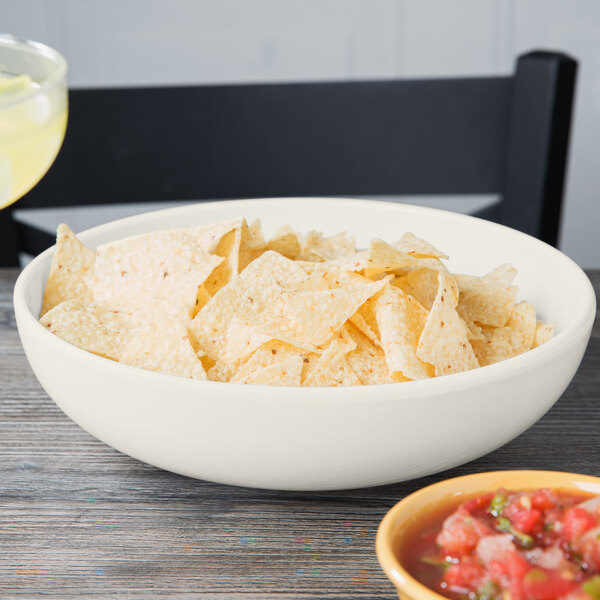 A Diamond Ivory melamine bowl filled with chips on a table.