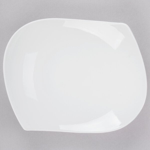 A CAC bone white porcelain peach plate with a curved edge.