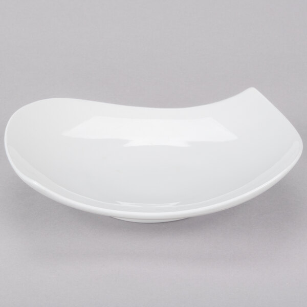 A bone white porcelain plate with a curved edge.