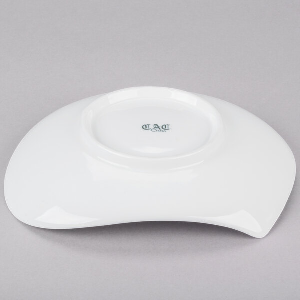 A CAC bone white porcelain plate with a curved edge.