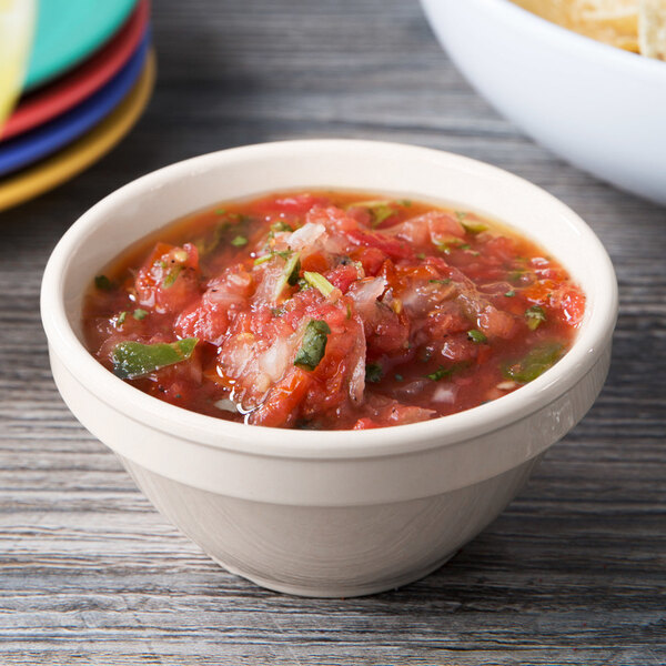 A Diamond Ivory melamine bowl filled with salsa on a table.