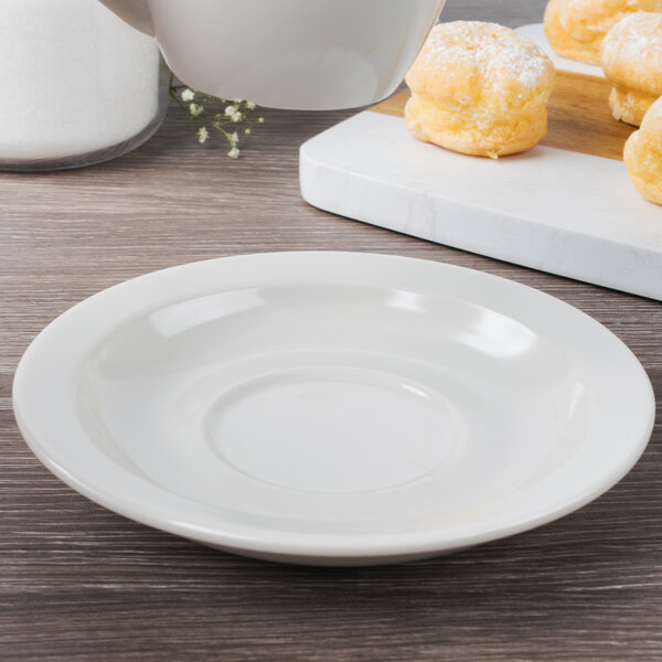 A Diamond Ivory melamine saucer with a pastry on it.