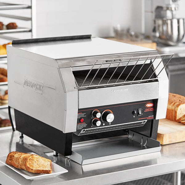 A Hatco Toast Qwik conveyor toaster on a counter with toast.