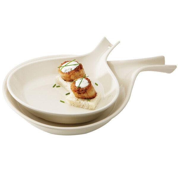Two ivory melamine skillets with food on them.
