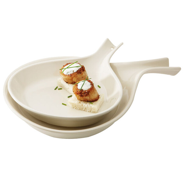 Two ivory melamine skillets with food on them.
