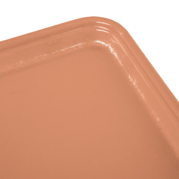 A dark peach rectangular Cambro fiberglass tray on a counter.