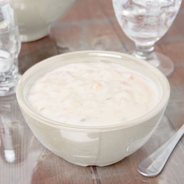 A Santa Fe Ironstone bowl of soup on a table with a spoon.