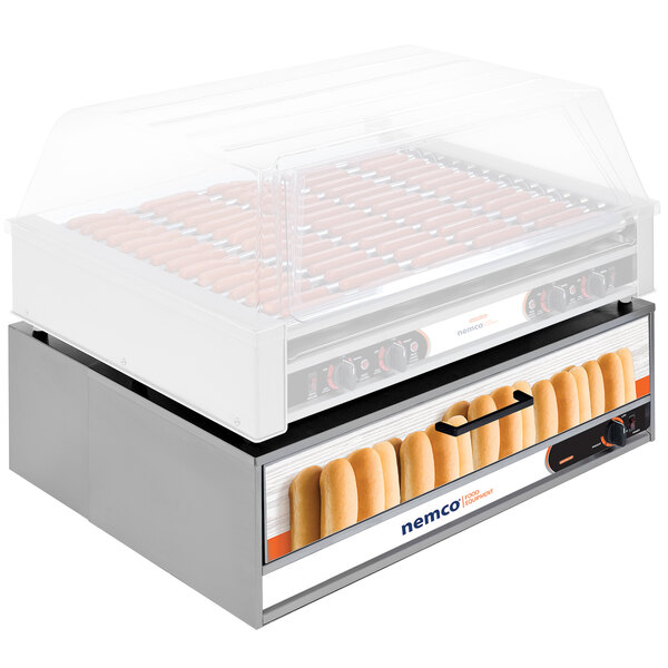 A Nemco hot dog bun warmer holding hot dog buns on a counter.