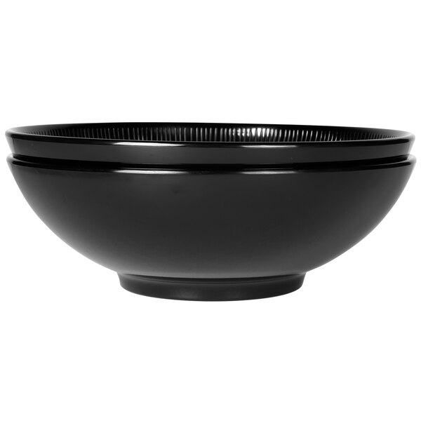 A close-up of a black Elite Global Solutions Sunburst melamine bowl with a rim.