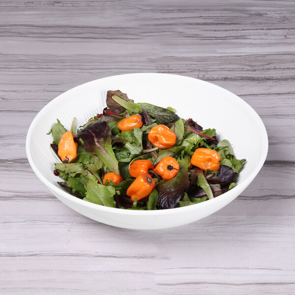 A Sunburst White melamine bowl filled with salad, tomatoes, and lettuce.