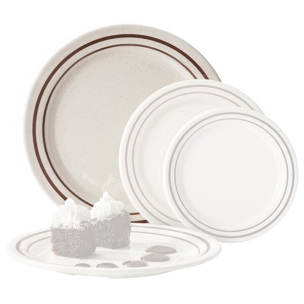 A close-up of a white GET Ultraware ironstone round plate with chocolate cake on it, with a group of white plates in the background.