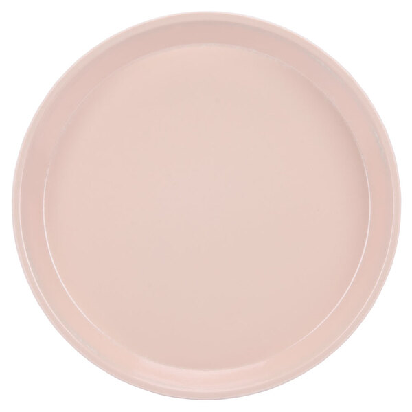 A close-up of a light pink Cambro round tray.