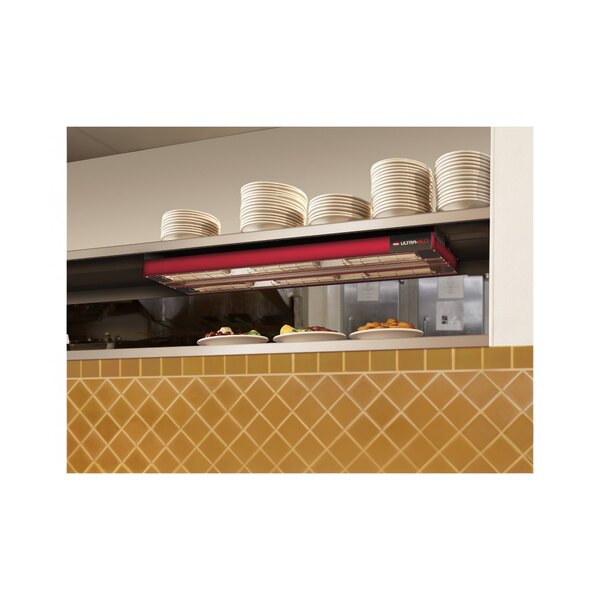 A kitchen counter with plates and bowls on top of a Hatco dual infrared strip warmer.