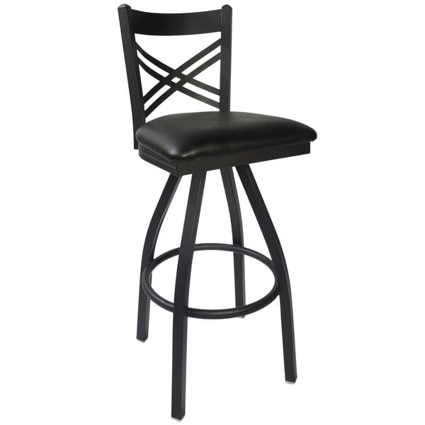 A BFM Seating black metal barstool with black vinyl swivel seat.