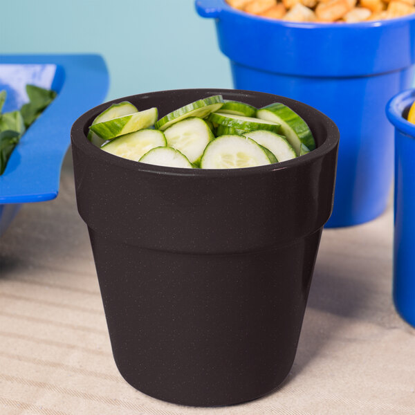 A black Tablecraft cast aluminum bowl with cucumbers in it.