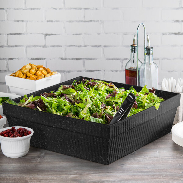 A salad in a black Tablecraft cast aluminum square bowl.