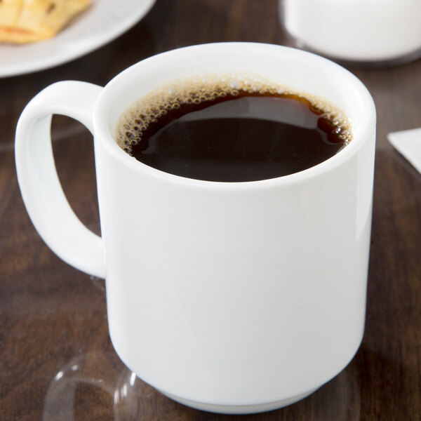 A white CAC Venice stacking mug with a brown liquid inside.