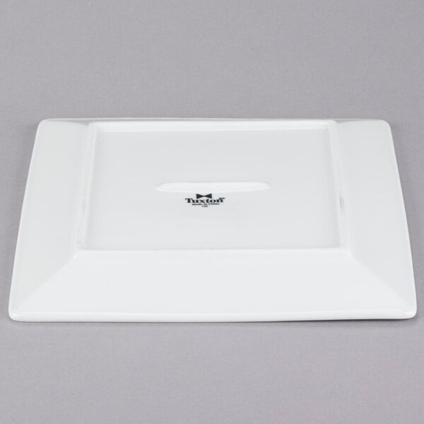 A white square Tuxton china plate with a small hole in the middle.