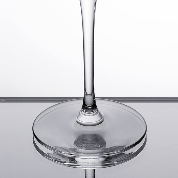 A close-up of a Chef & Sommelier round wine glass filled with clear liquid.