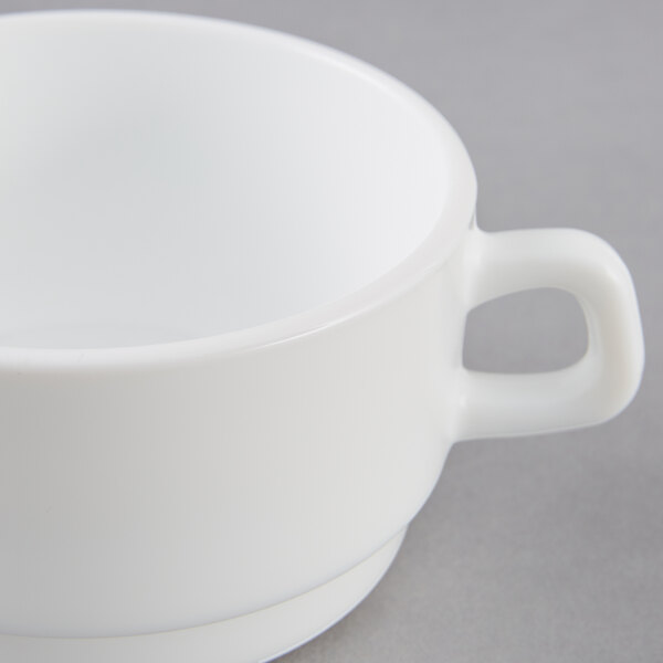 A close up of a white Arcoroc double handled bowl.