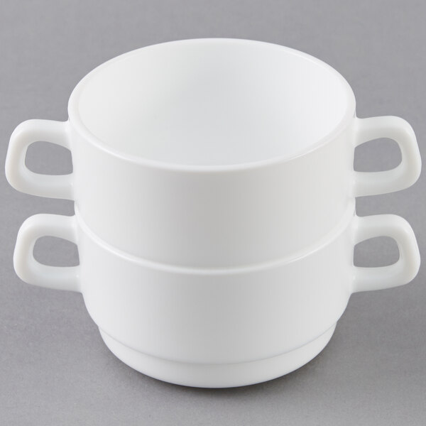 An Arcoroc white opal glass bowl with two handles.