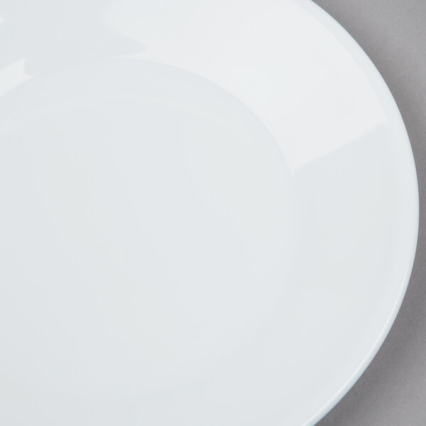 An Arcoroc white glass bread and butter plate with a silver rim.