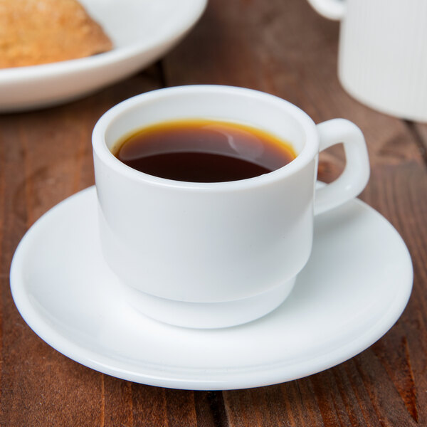 A white Arcoroc restaurant cup of coffee on a saucer.