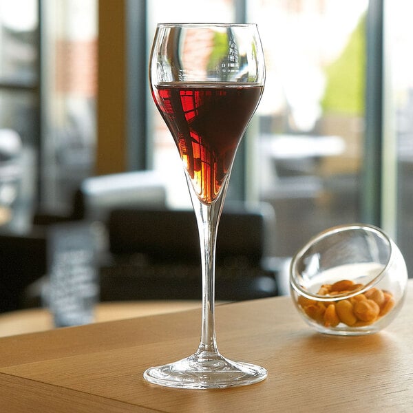 A close-up of a Arcoroc Brio flute of red wine on a table.
