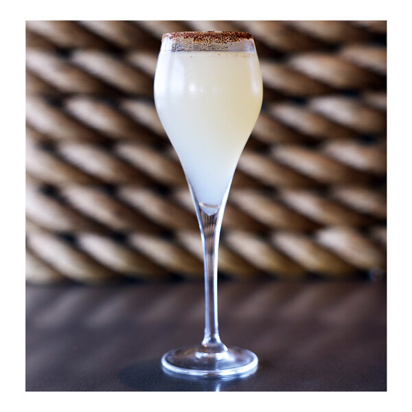 A close-up of a Arcoroc Brio Flute filled with white liquid.