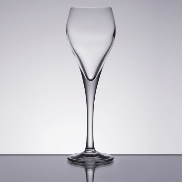 An Arcoroc Malea Brio wine glass on a table with a reflection.