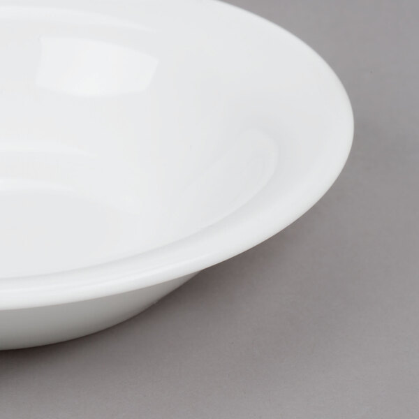 An Arcoroc white opal fruit bowl with a white rim.