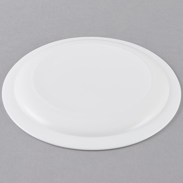 An Arcoroc white glass lunch plate with a narrow rim.