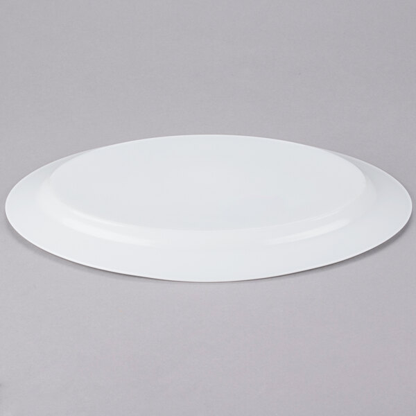 An Arcoroc white oval platter on a gray surface.