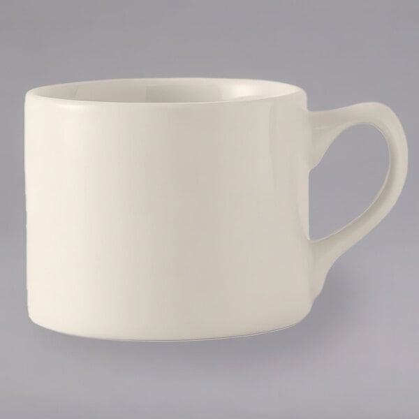 A white Tuxton China steakhouse cup with a black handle.