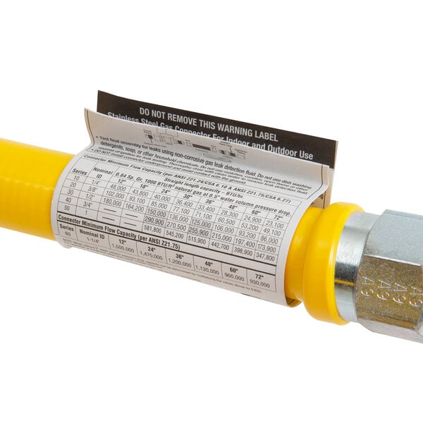 A stainless steel Dormont gas connector hose with a yellow label.