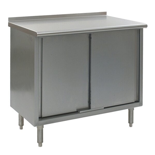 A stainless steel Eagle Group work table with cabinet base and doors.