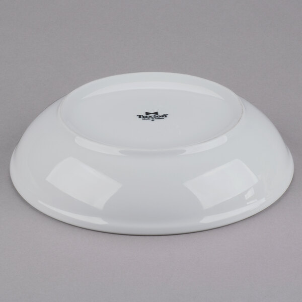 A white china pasta bowl with a black rim.